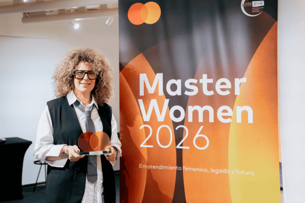 Retrato de Sara Sorribes sonriendo con el trofeo MasterWoman 2026 frente al cartel oficial del evento.